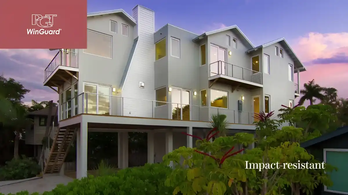 Modern coastal home with PGT WinGuard impact-resistant windows at dusk