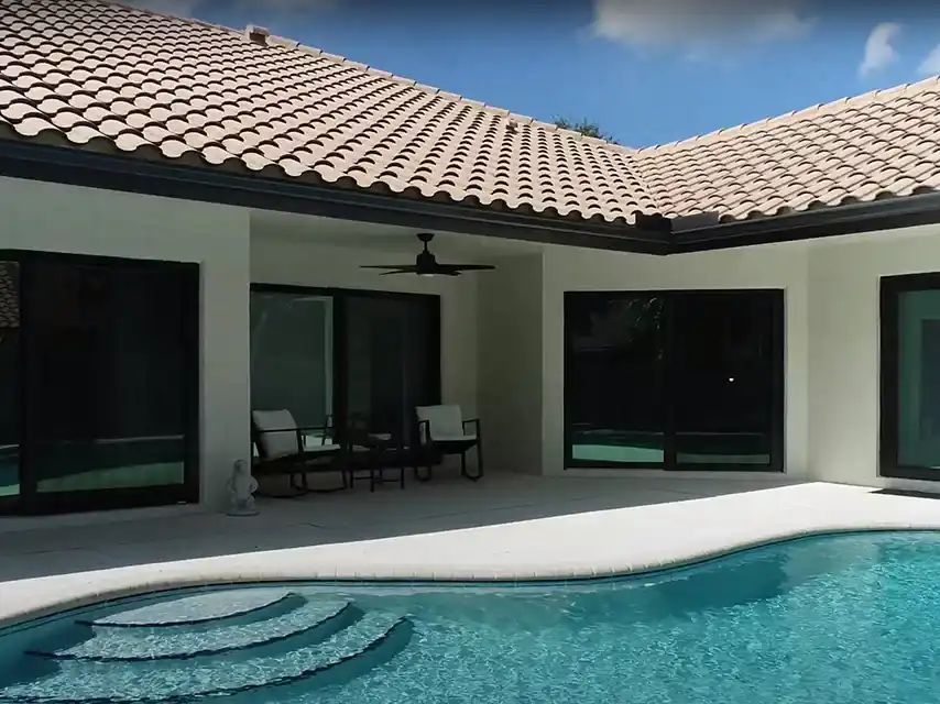 Black-framed impact sliding glass doors on South Florida pool home