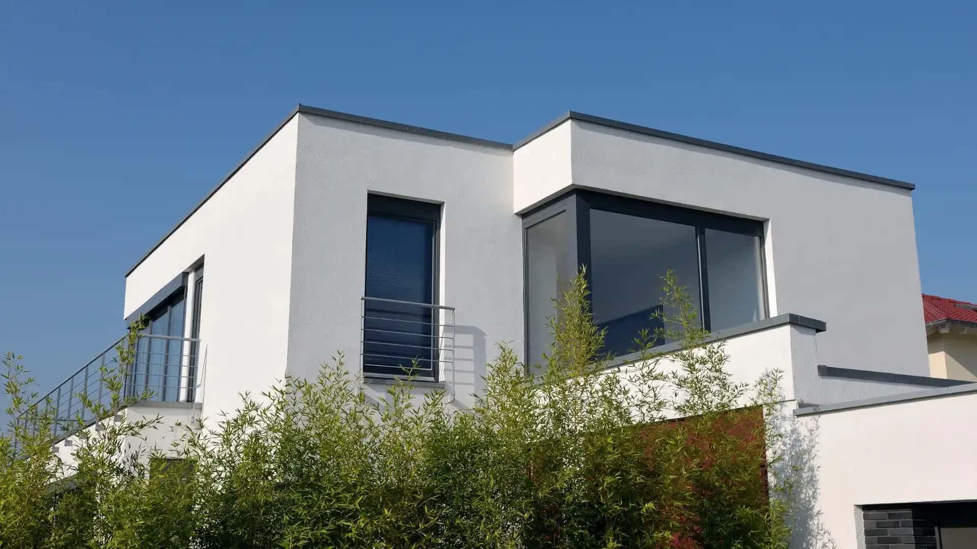 Modern home with large dark-framed impact windows and flat roof