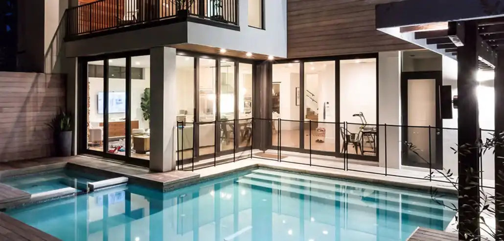 Modern home with black-framed impact sliding glass doors overlooking pool