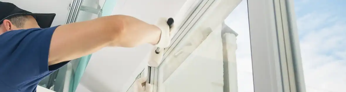 Technician installing white aluminum impact window in South Florida home