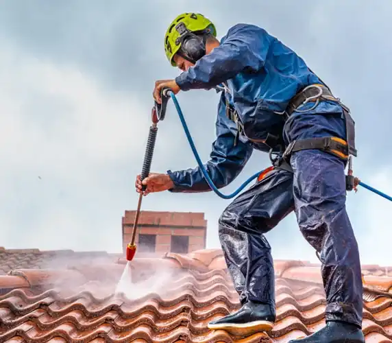 Roofer pressure washing clay tile roof in South Florida