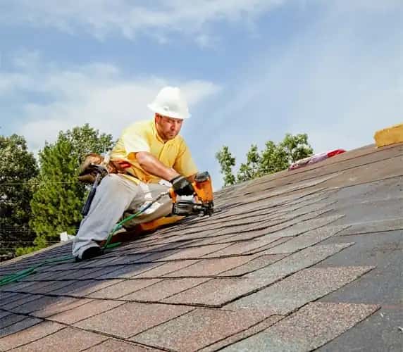 Roofer installing asphalt shingles on South Florida residential roof