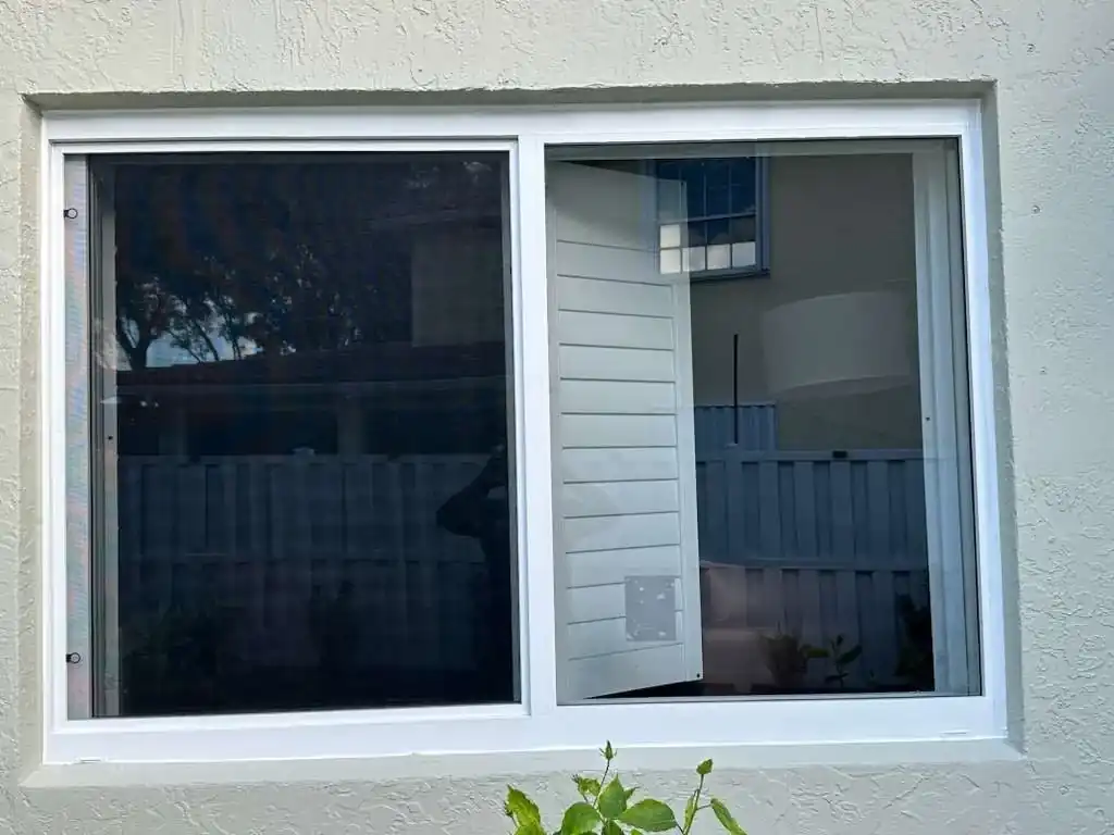White frame impact sliding window installed on stucco home exterior