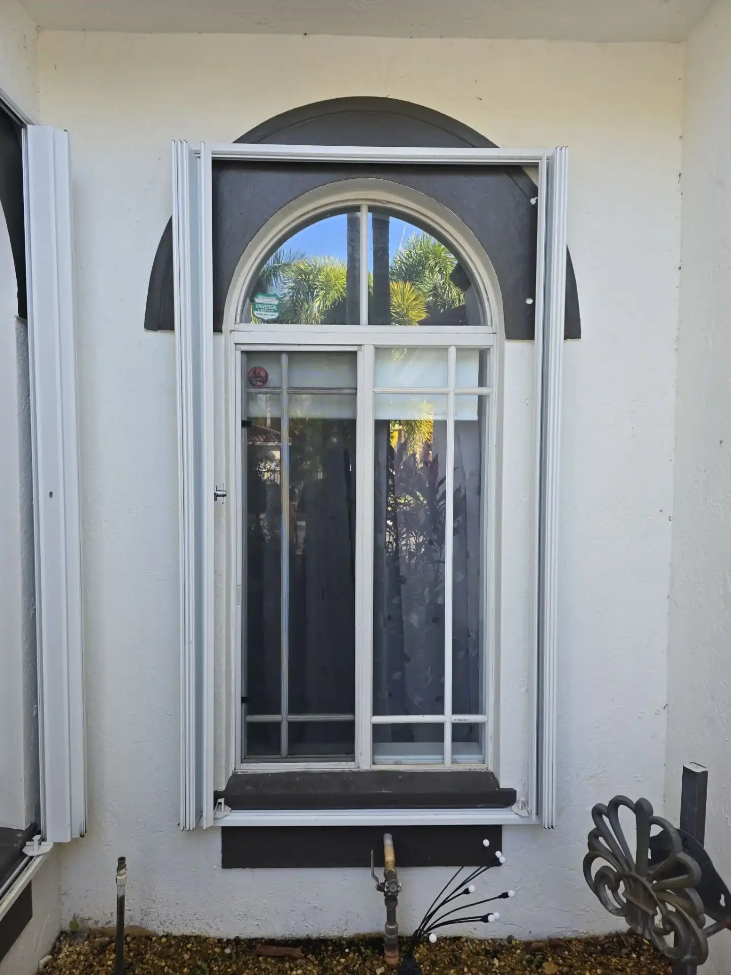 White arched transom impact window installed on South Florida stucco home