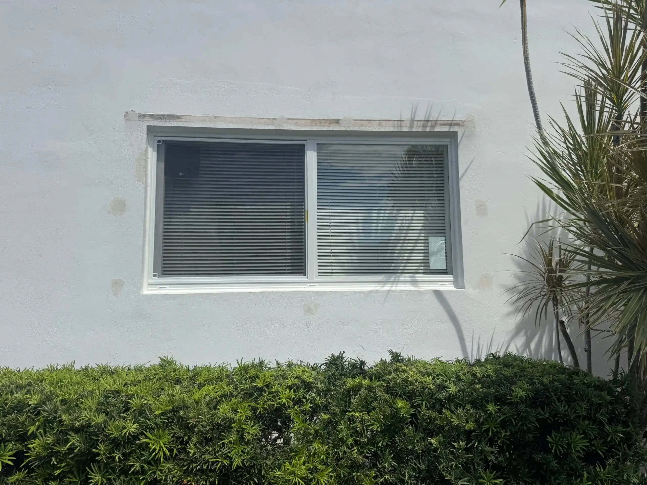 Impact sliding window installed on white stucco home in Hollywood FL