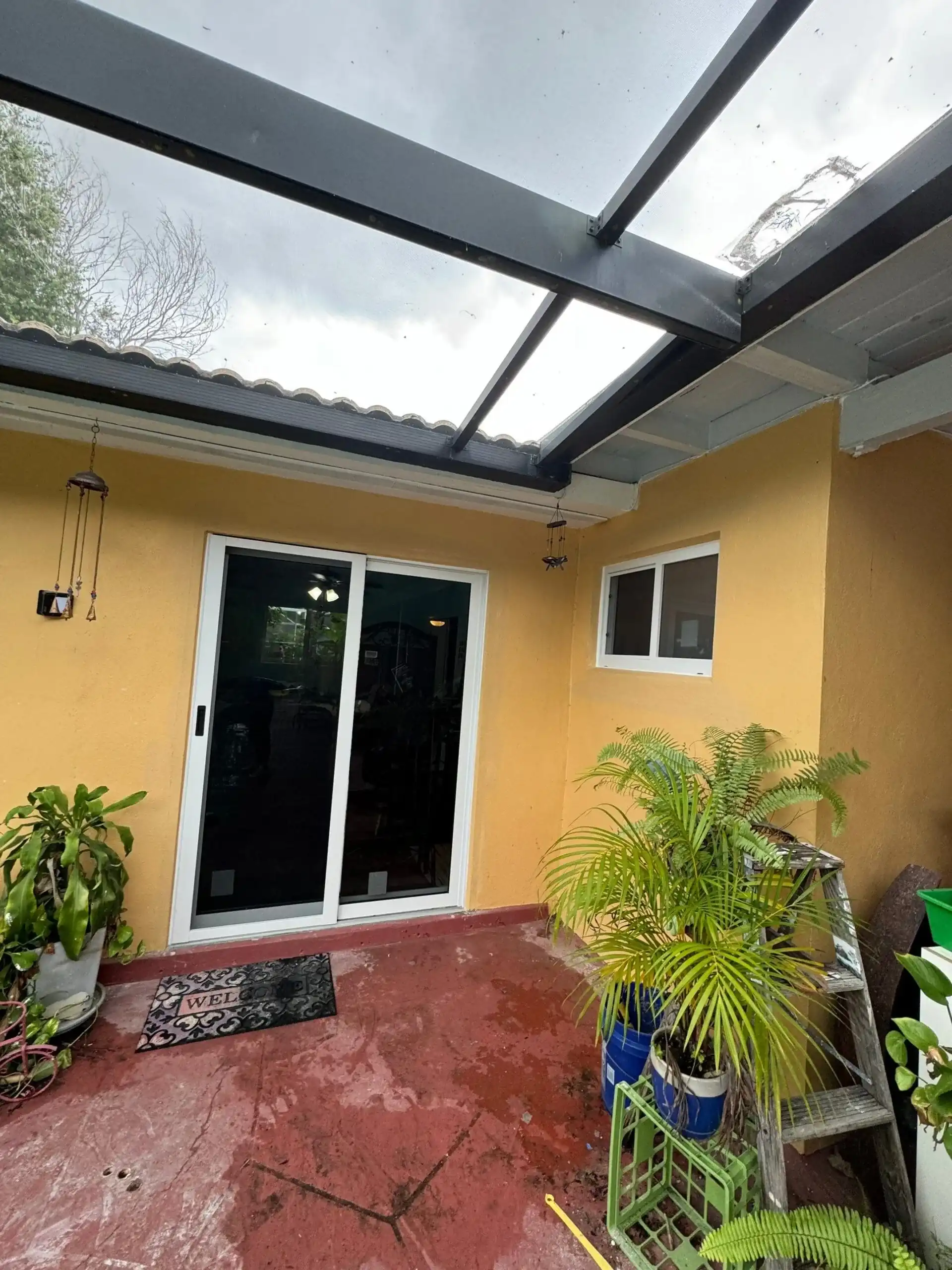 White impact sliding glass door on yellow stucco home patio Plantation FL
