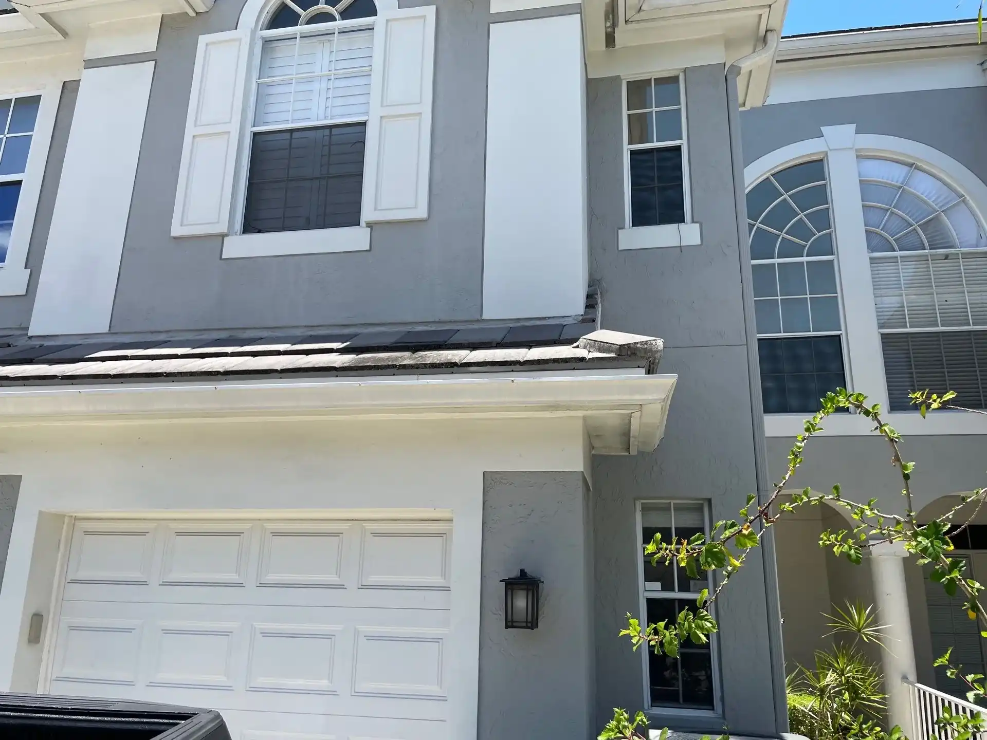 Gray two-story Boca Raton home with white-trimmed impact windows