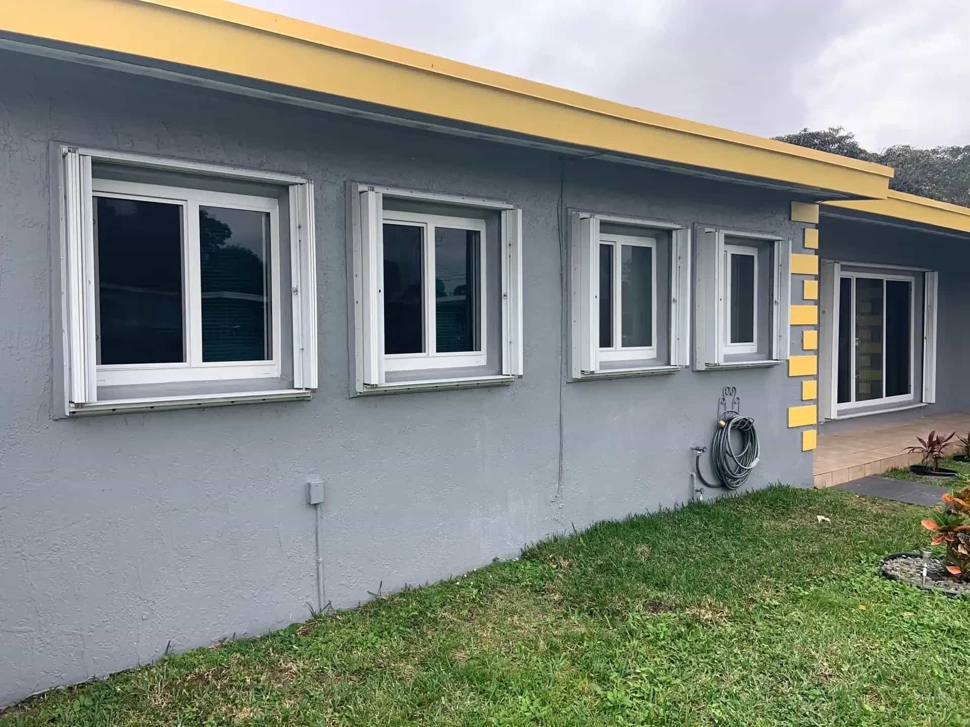 White impact windows installed on gray stucco Miami Gardens home