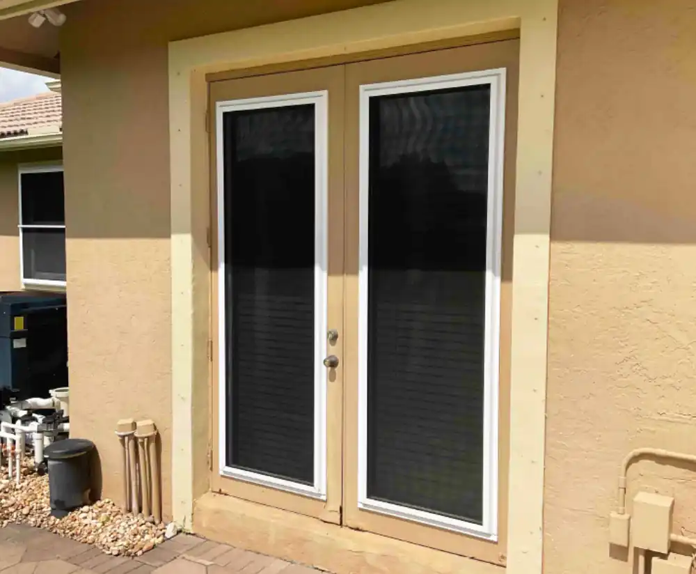 Older white French doors on a stucco home