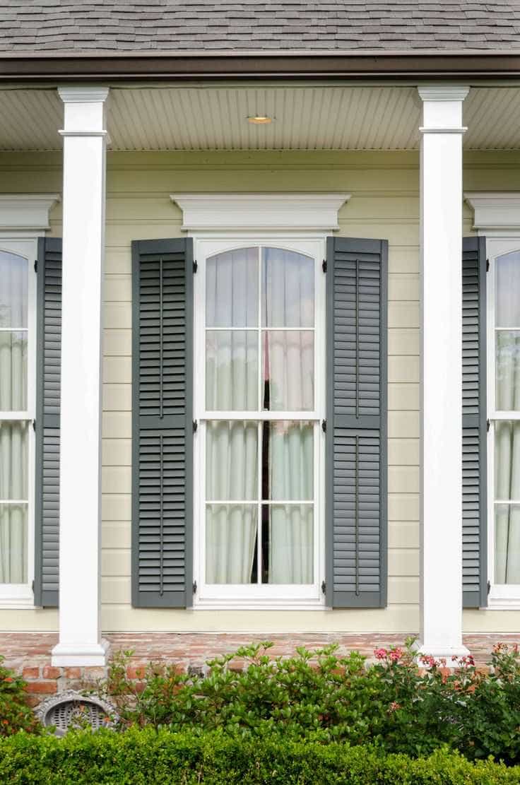 White double-hung windows with gray shutters on classic home exterior