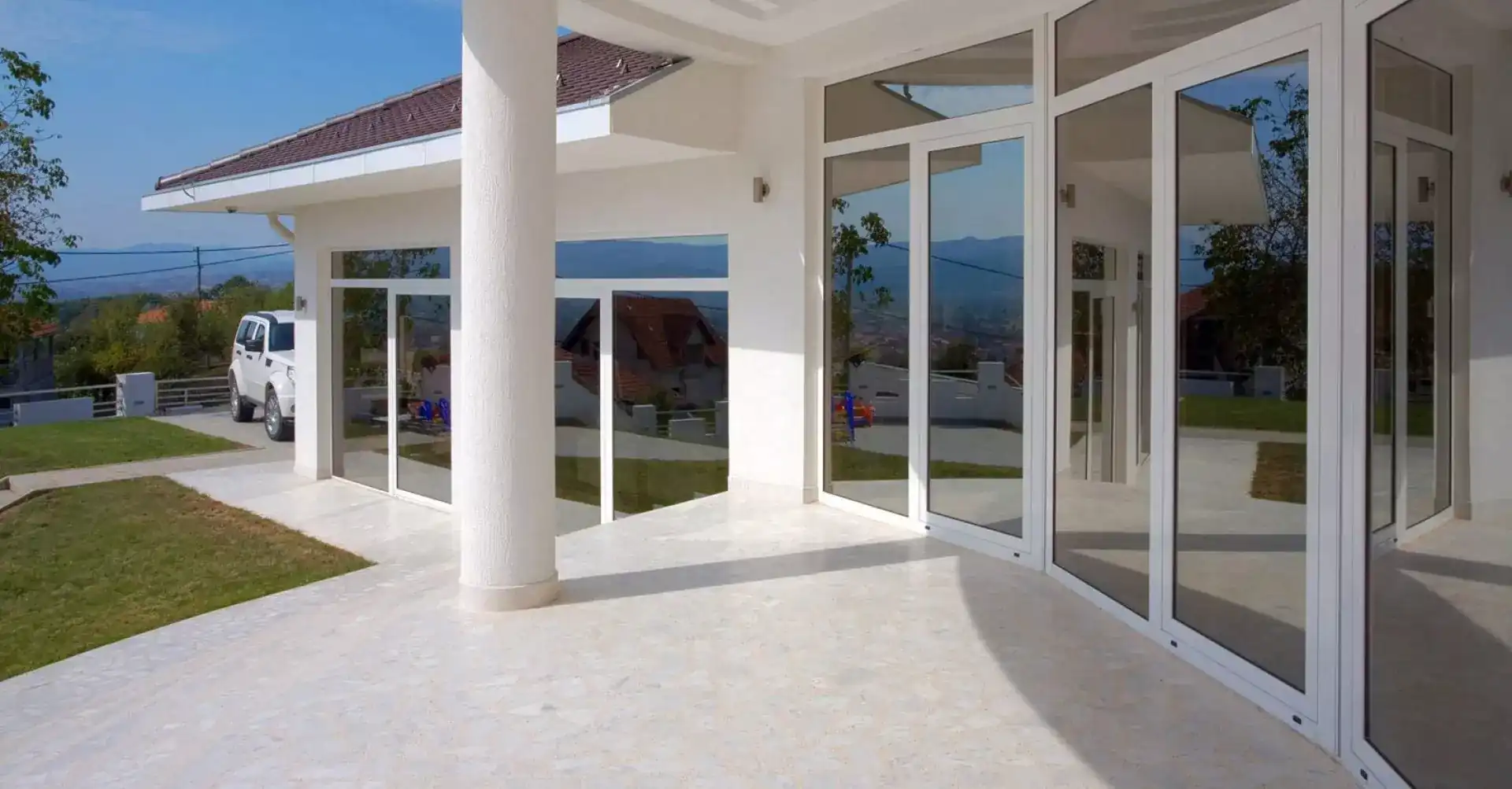 Impact windows and sliding glass doors on modern white home exterior