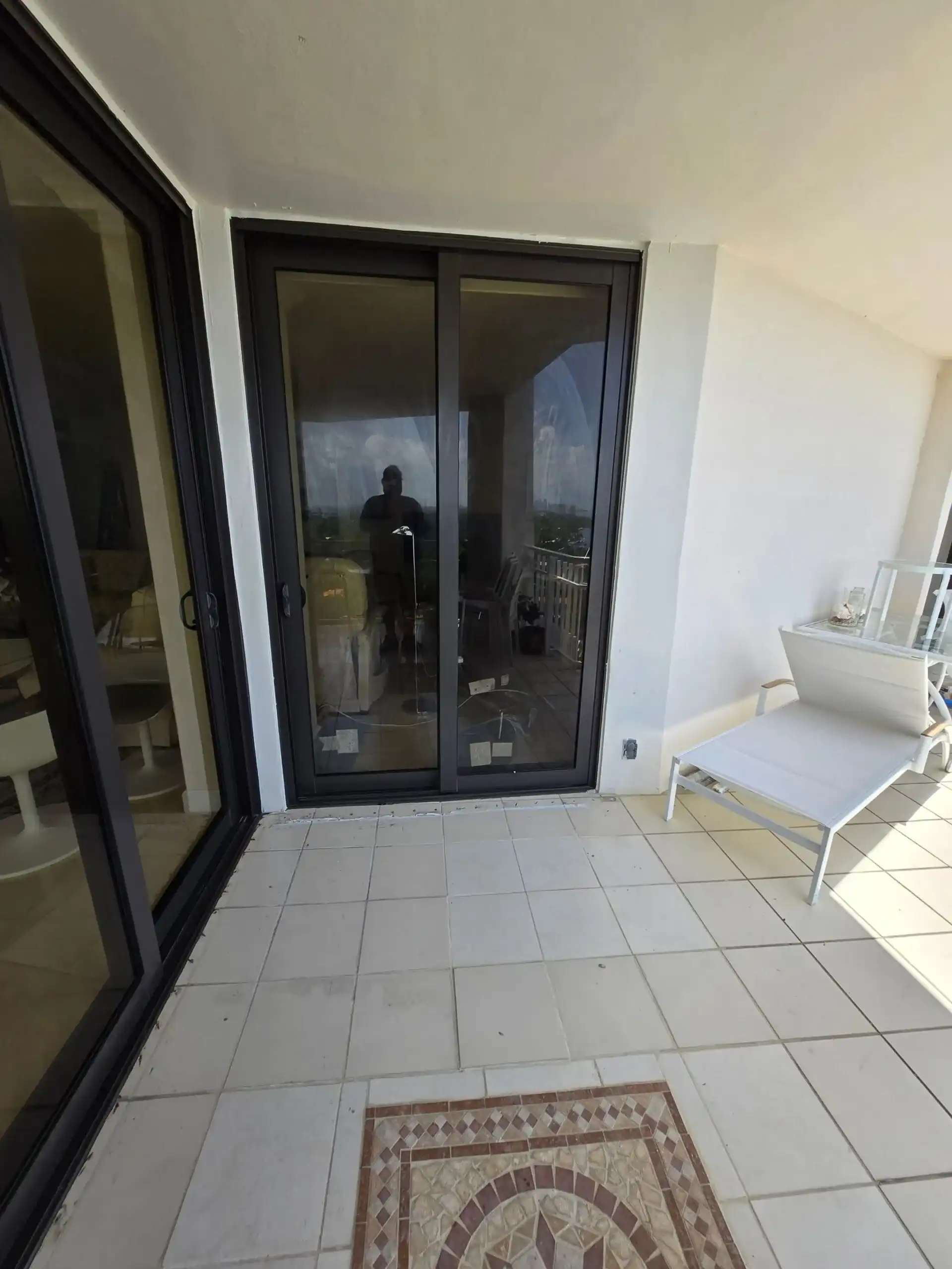 Dark-frame impact sliding glass doors on South Florida condo balcony
